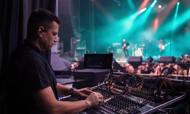 音楽フェスのステージ脇で音声機材を確認するスタッフ